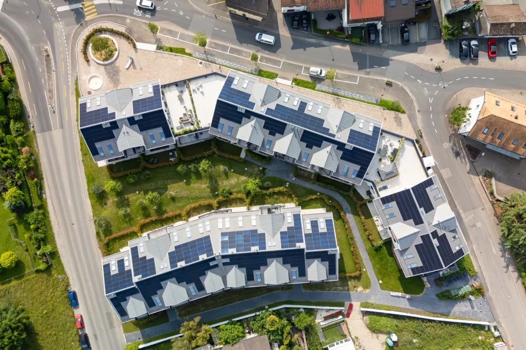 Vue aérienne des panneaux solaires et jardin de la promotion neuve à Denges